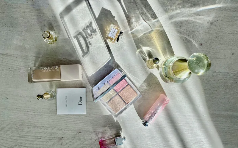 High-angle shot of Dior cosmetics and perfumes casting artistic shadows.