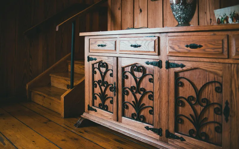Warm wooden sideboard and staircase in a cozy, rustic interior.
