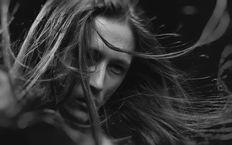 Dramatic black and white portrait highlighting expressive emotions and flowing hair.
