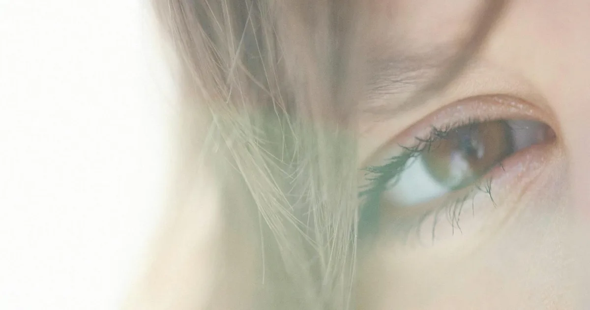 Close-up of a woman's eye with soft natural light enhancing features.