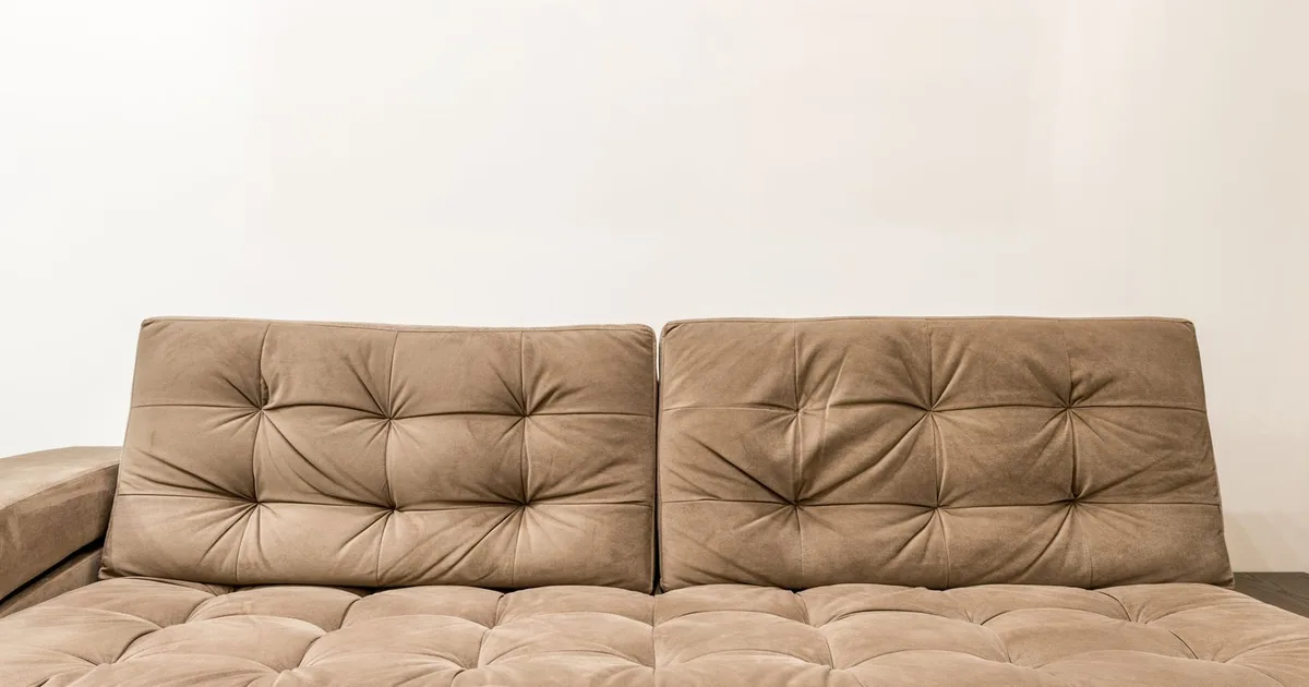 Comfortable brown couch with tufted design in contemporary living room setting.