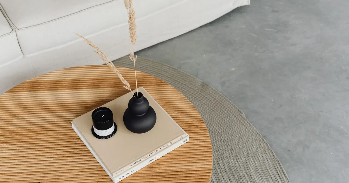Stylish living room table with a black vase, books, and comfortable couch.