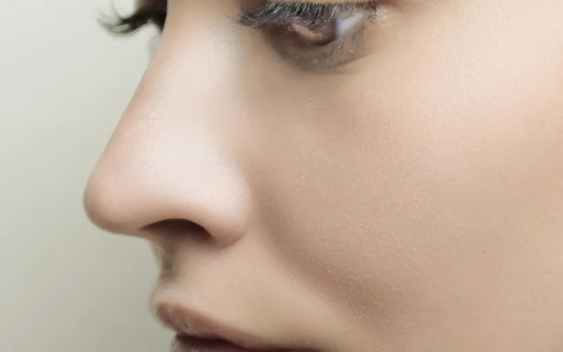 Detailed side profile of a woman's face with flawless skin and subtle makeup.