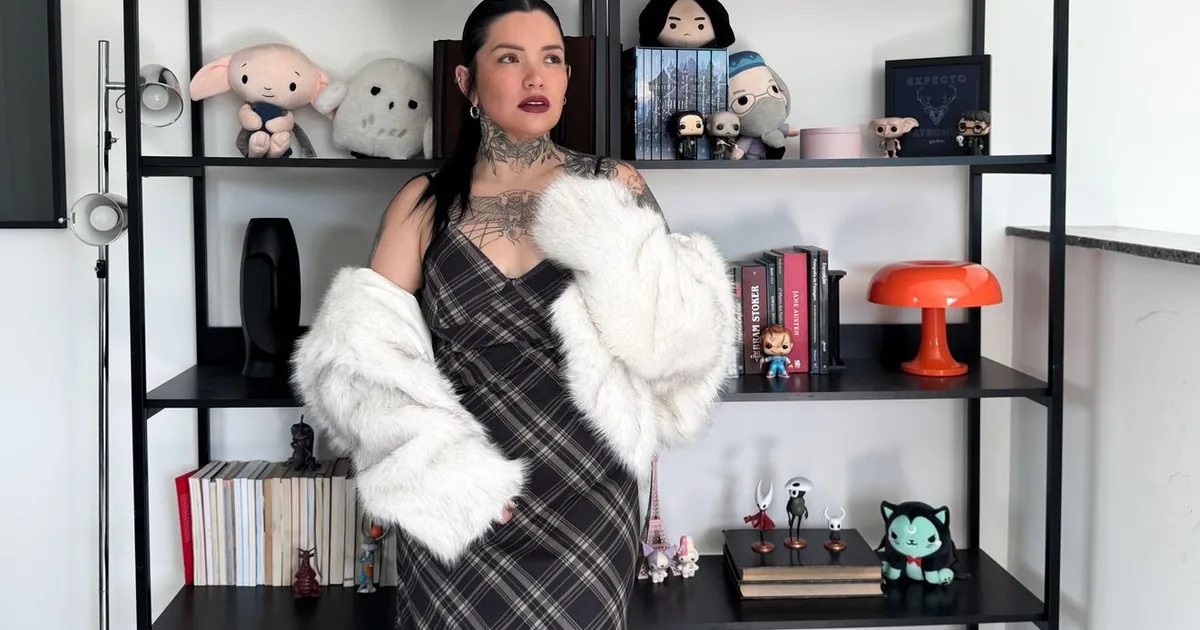 Fashionable woman in a stylish interior surrounded by eclectic decor and books.