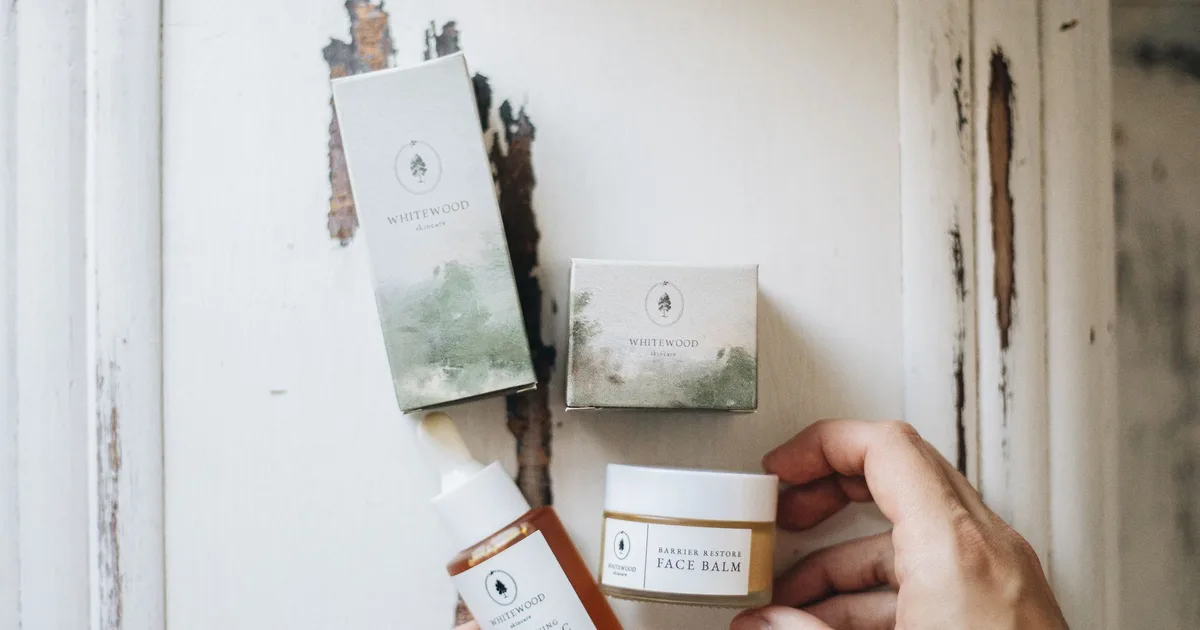 High-angle view of natural skincare products featuring face serum and balm with eco-friendly packaging.