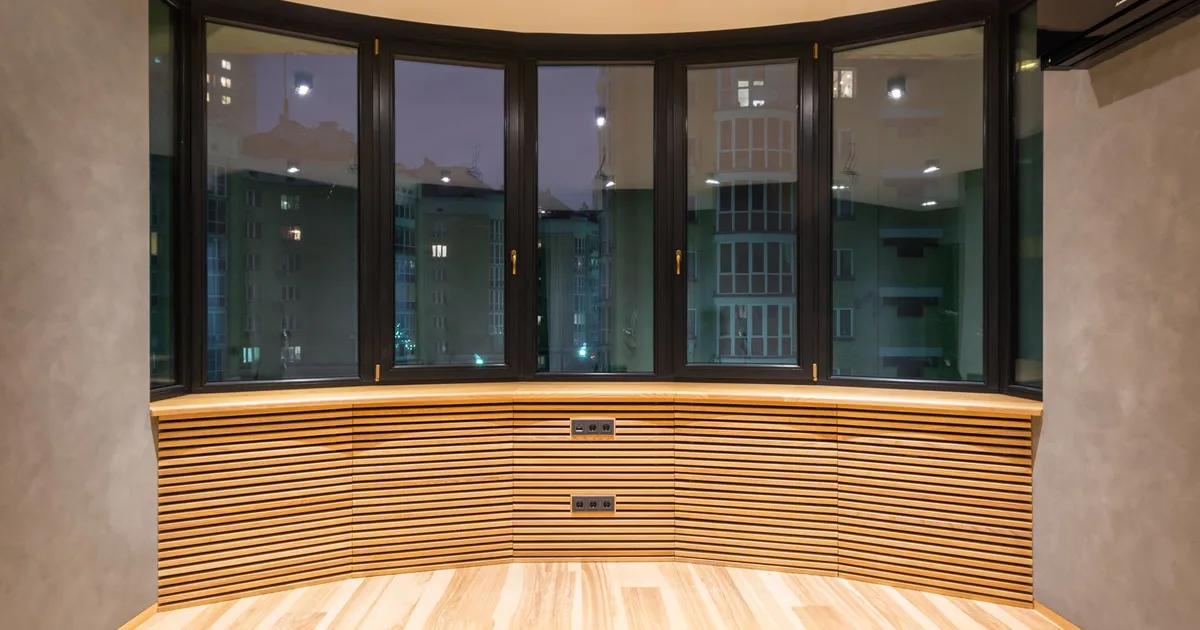 Contemporary empty room with windows and parquet under bright lamps against air conditioning in urban house