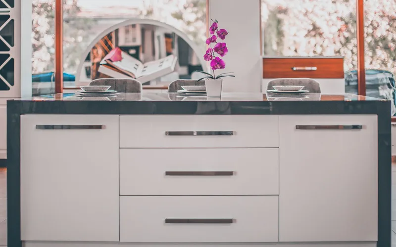 Contemporary kitchen island with an elegant orchid decoration and stylish furniture.