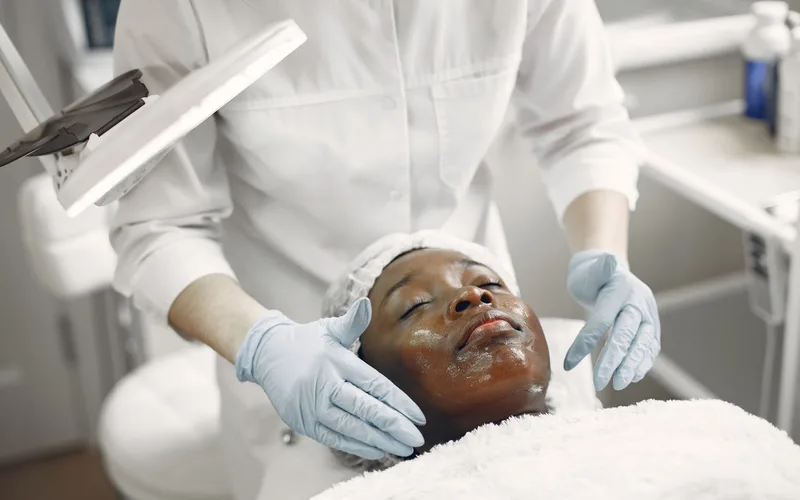 A client enjoys a soothing facial treatment in a modern skincare clinic, promoting wellness and relaxation.