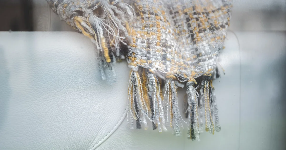 Close-up of a textured throw blanket draped on a light-colored sofa, showcasing cozy home decor.