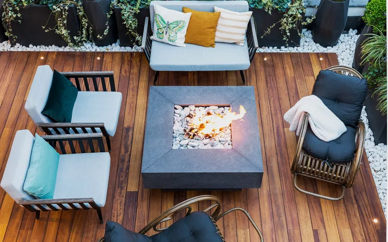 A top-down view of a modern patio featuring stylish furniture and a central firepit.