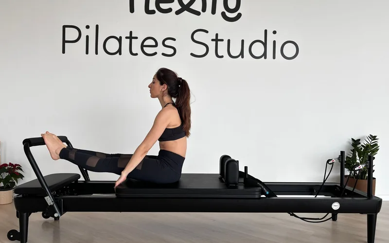 Adult woman performing Pilates exercise on reformer at Flexity Pilates Studio.
