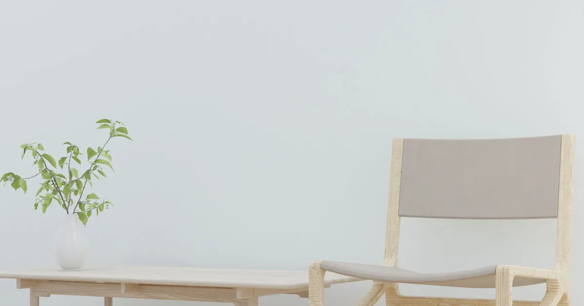 Bright minimalist interior featuring a wooden chair and tabletop plant.