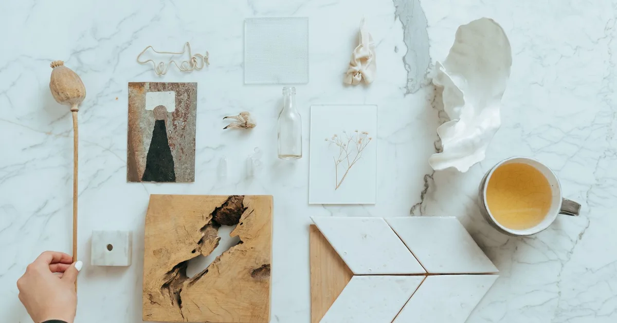 Minimalistic flat lay featuring diverse items on a marble background, showcasing natural textures.