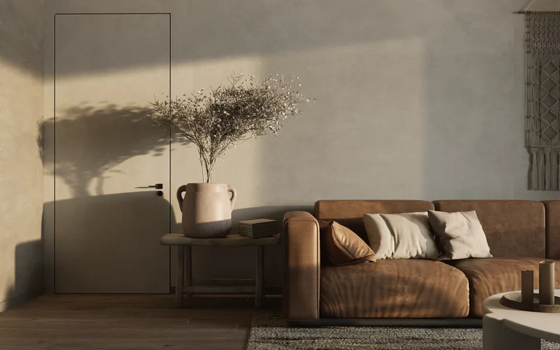 Warm minimalist living room featuring a brown sofa and decorative elements.