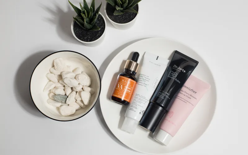 A flat lay of skincare products on a plate with decorative elements.